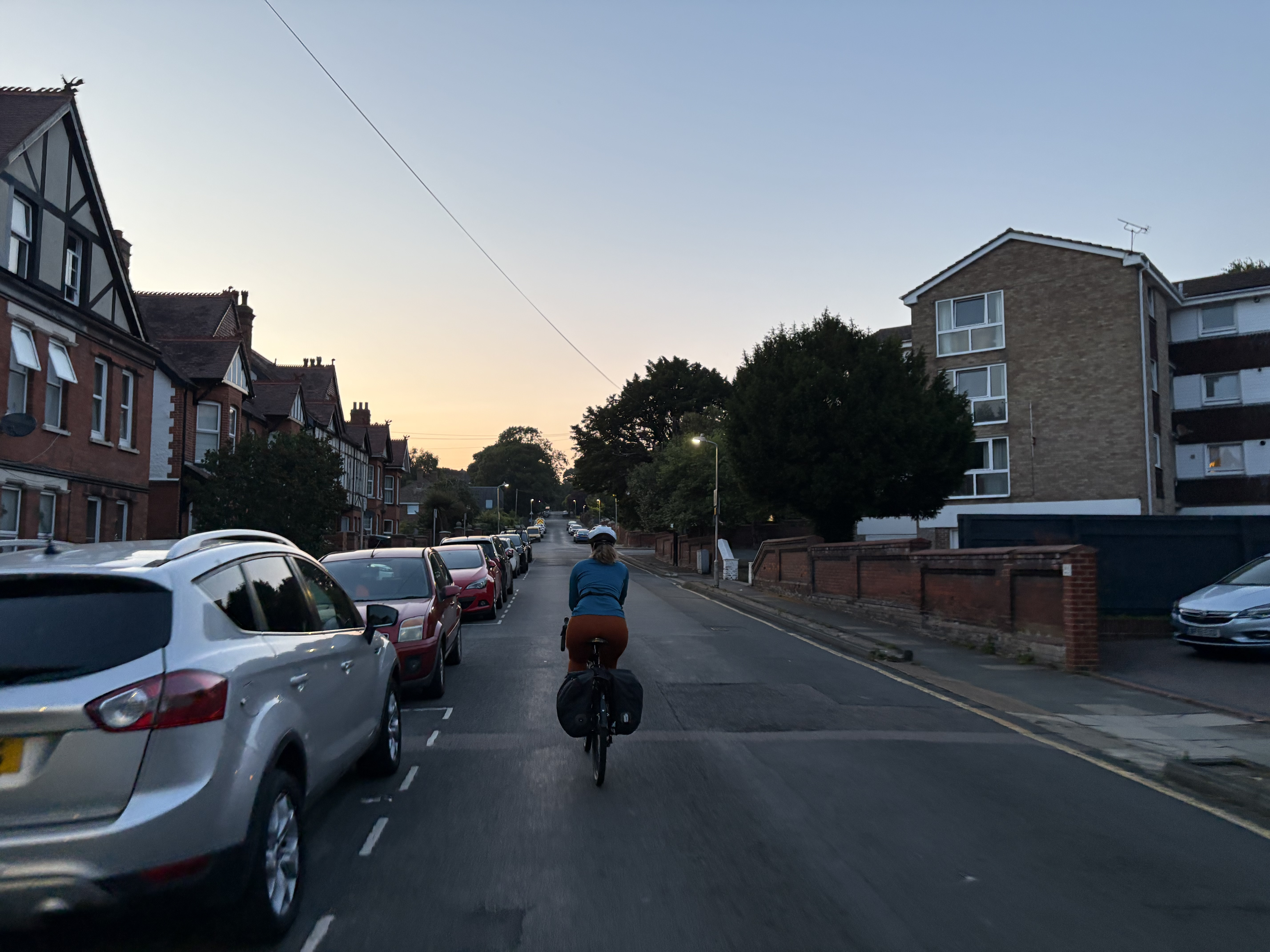 Sam riding up the road in Dover, with the sun going down in the background