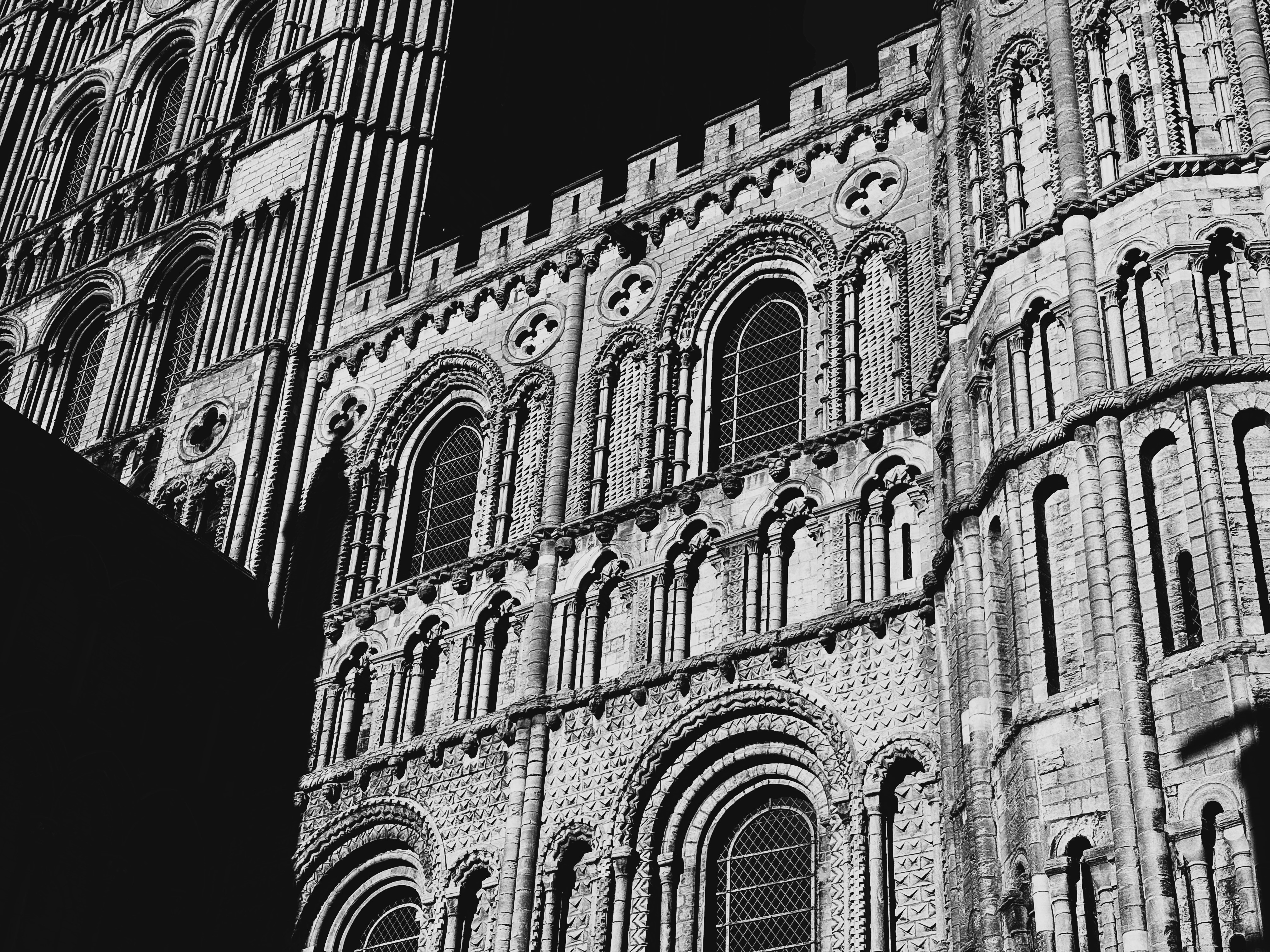 A dramatic black and white shot of sharp shadows on the face of Ely Cathedral, looking very abstract and geometric.