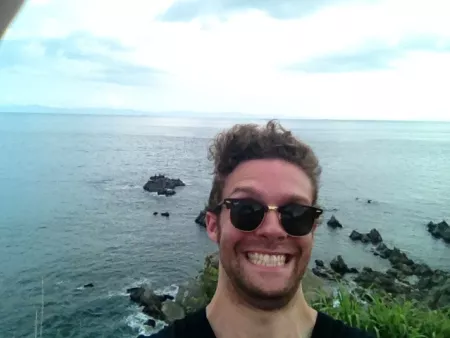 Selfie of me in front of the Tsugaru Straits, mugging for the camera with a big doofy grin