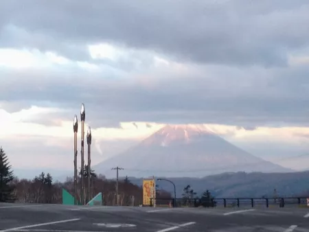 Mount Yotei from a nearby mountain pass, a big triangle of a mountain sticking up into the clouds