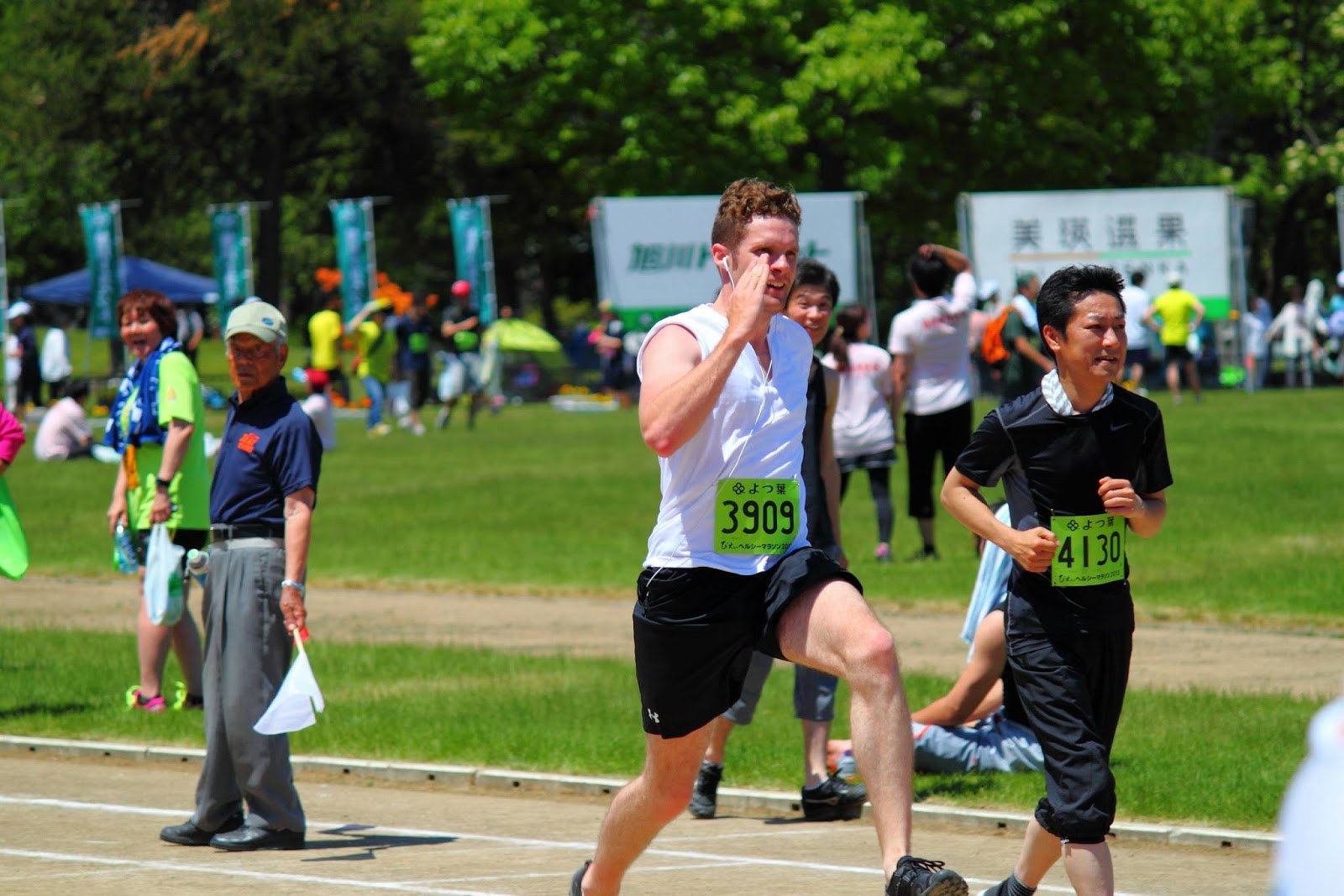 Me running full-out at the end of the Biei Healthy Marathon, a couple of incredulous-looking folks standing around in the background