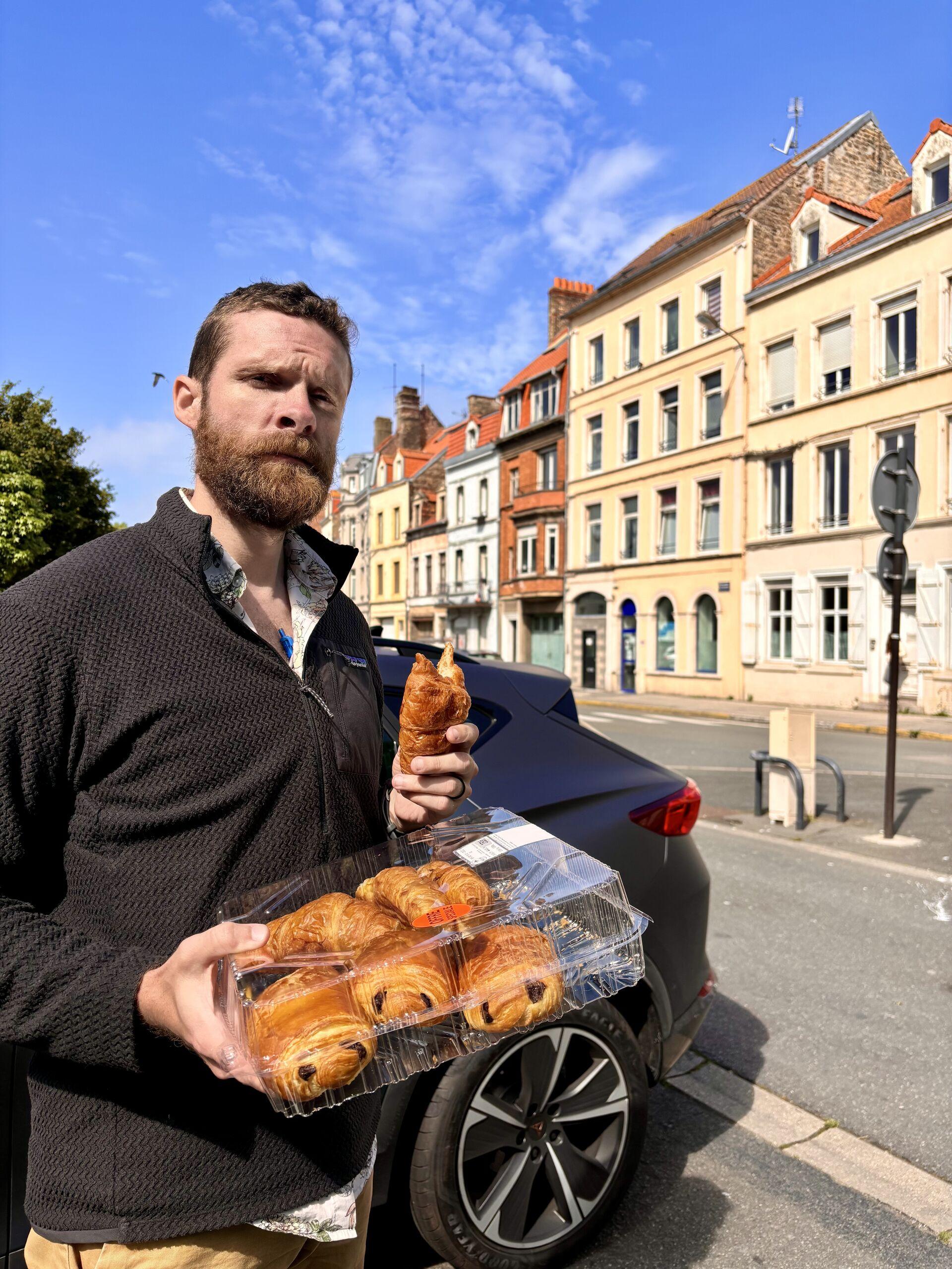 Me, standing pensively before the mismatched row houses of Boulogne, holding a plastic variety box of croissants