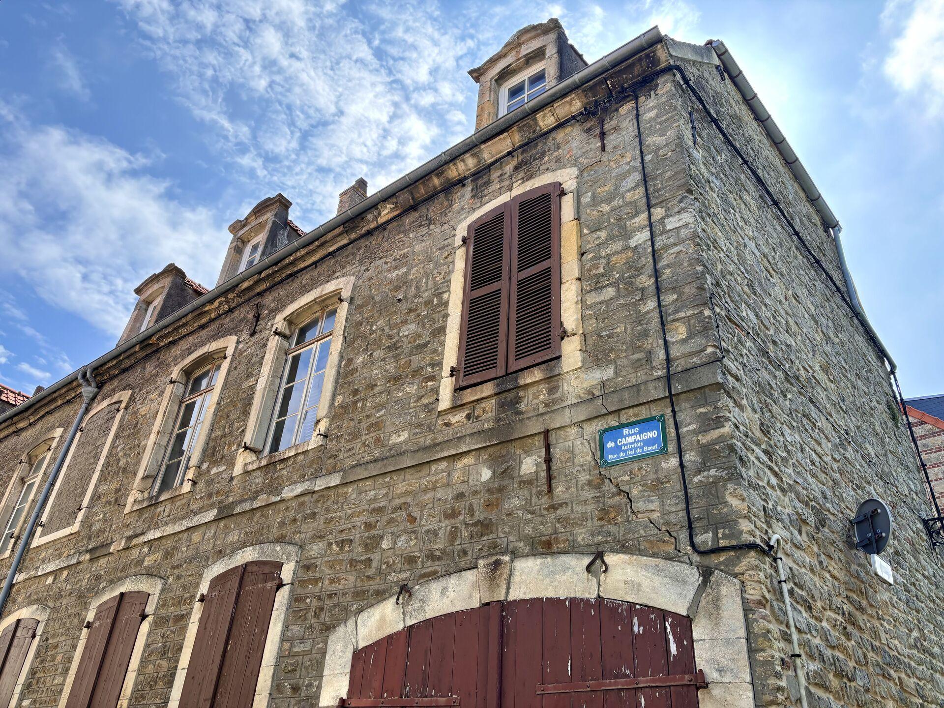 Looking up at the shuttered windows of an old stone house