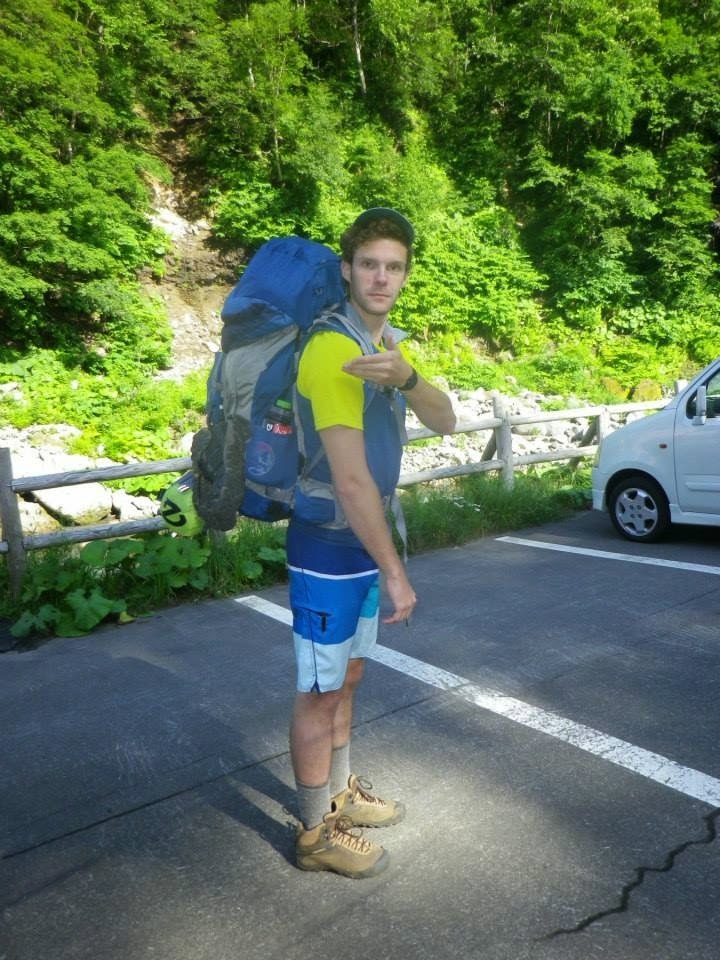 Me, standing in a car park, gesturing poignantly at the size of the backpack I'm wearing