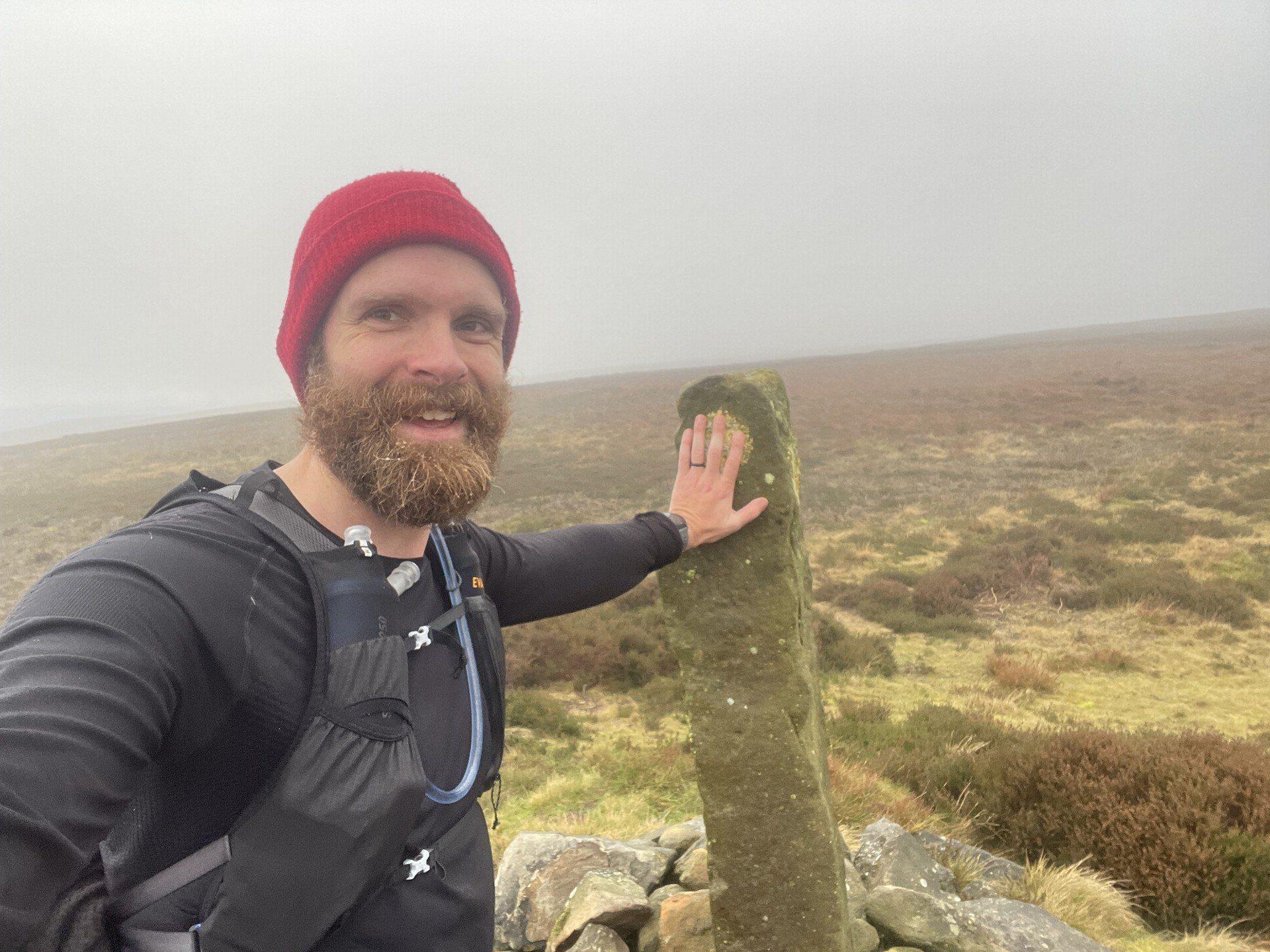 A selfie with the standing stone at Cock Howe, the background thick with fog