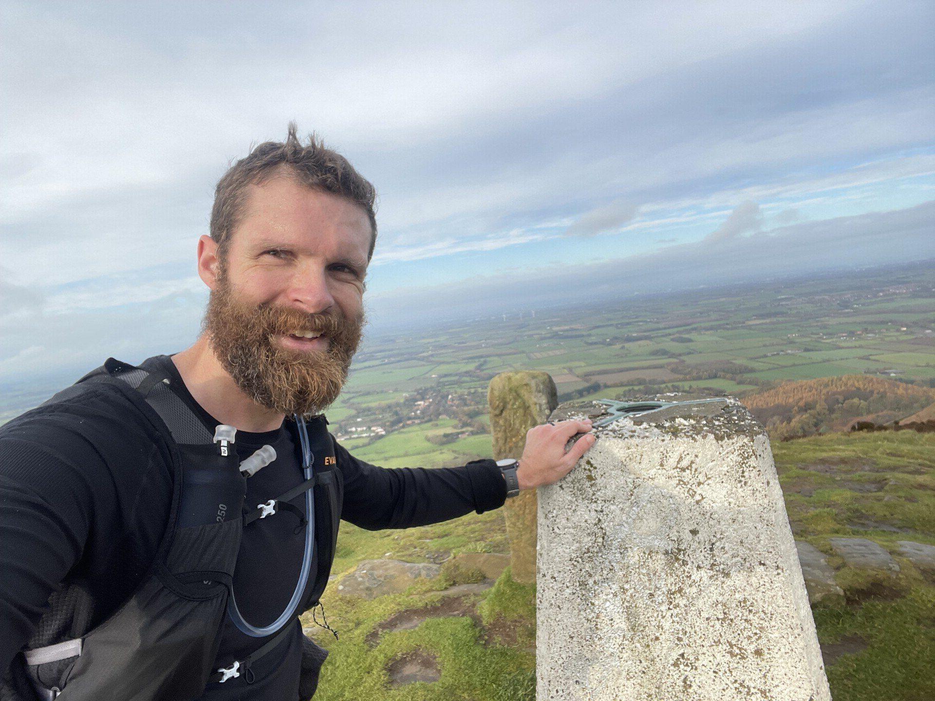 A selfie I took with the trig point atop Drake Howe, with Teesside stretching off into the clouds behind me