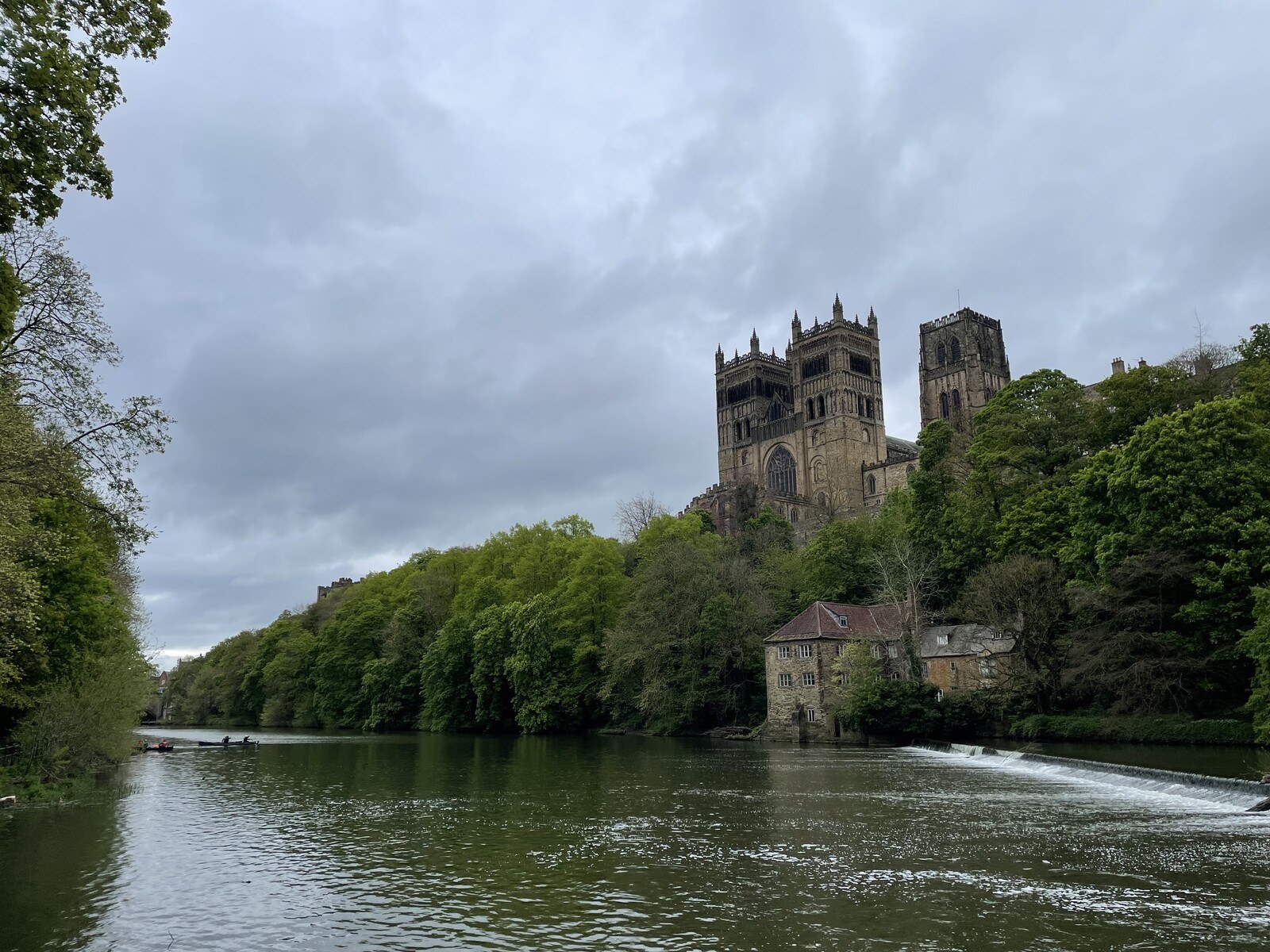Durham Cathedral rising above the trees on the banks of the River Wear, with the old Fulling Mill in the foreground