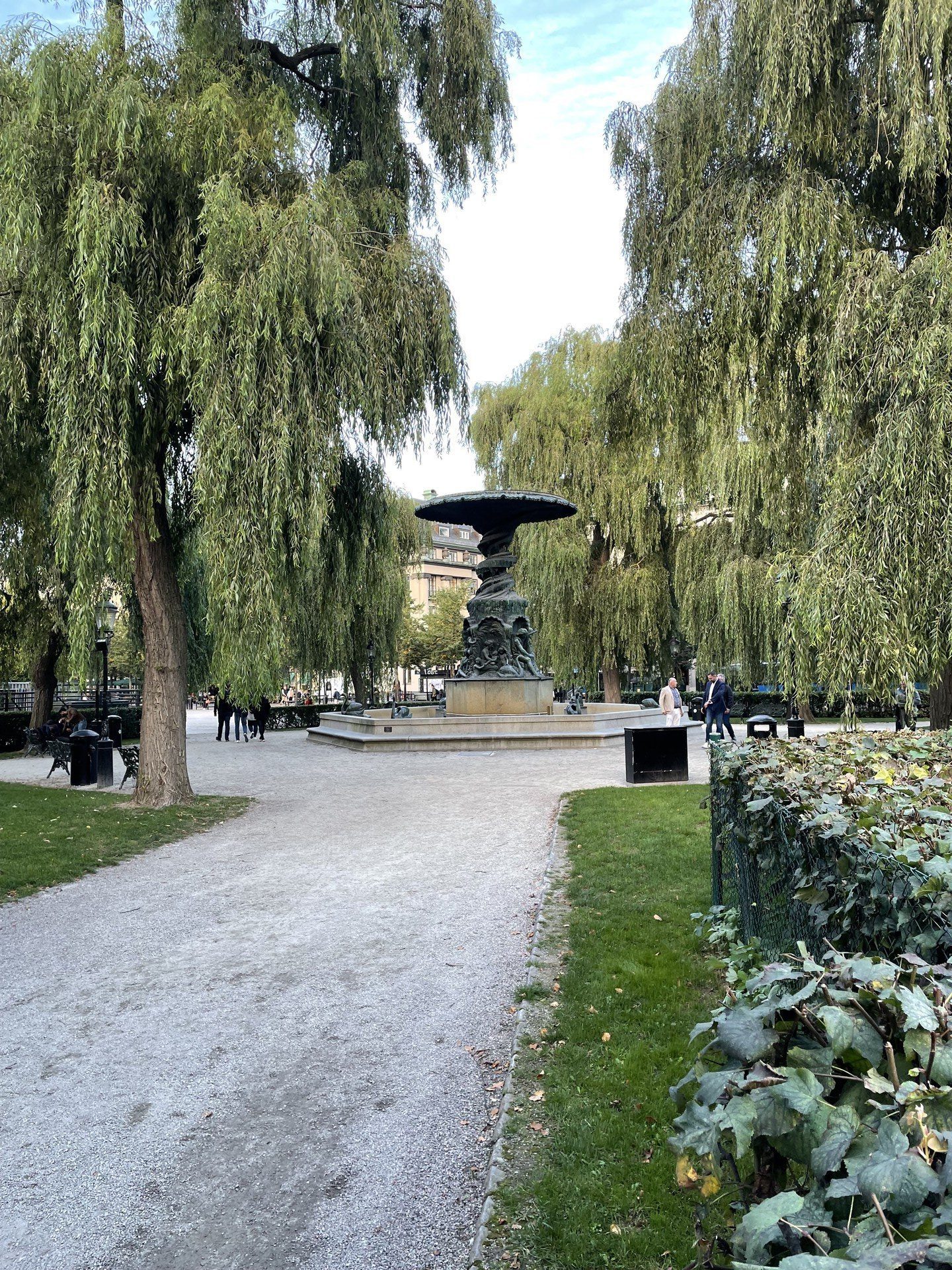 A big cast-iron fountain in a park, but with no water coming out of it.
