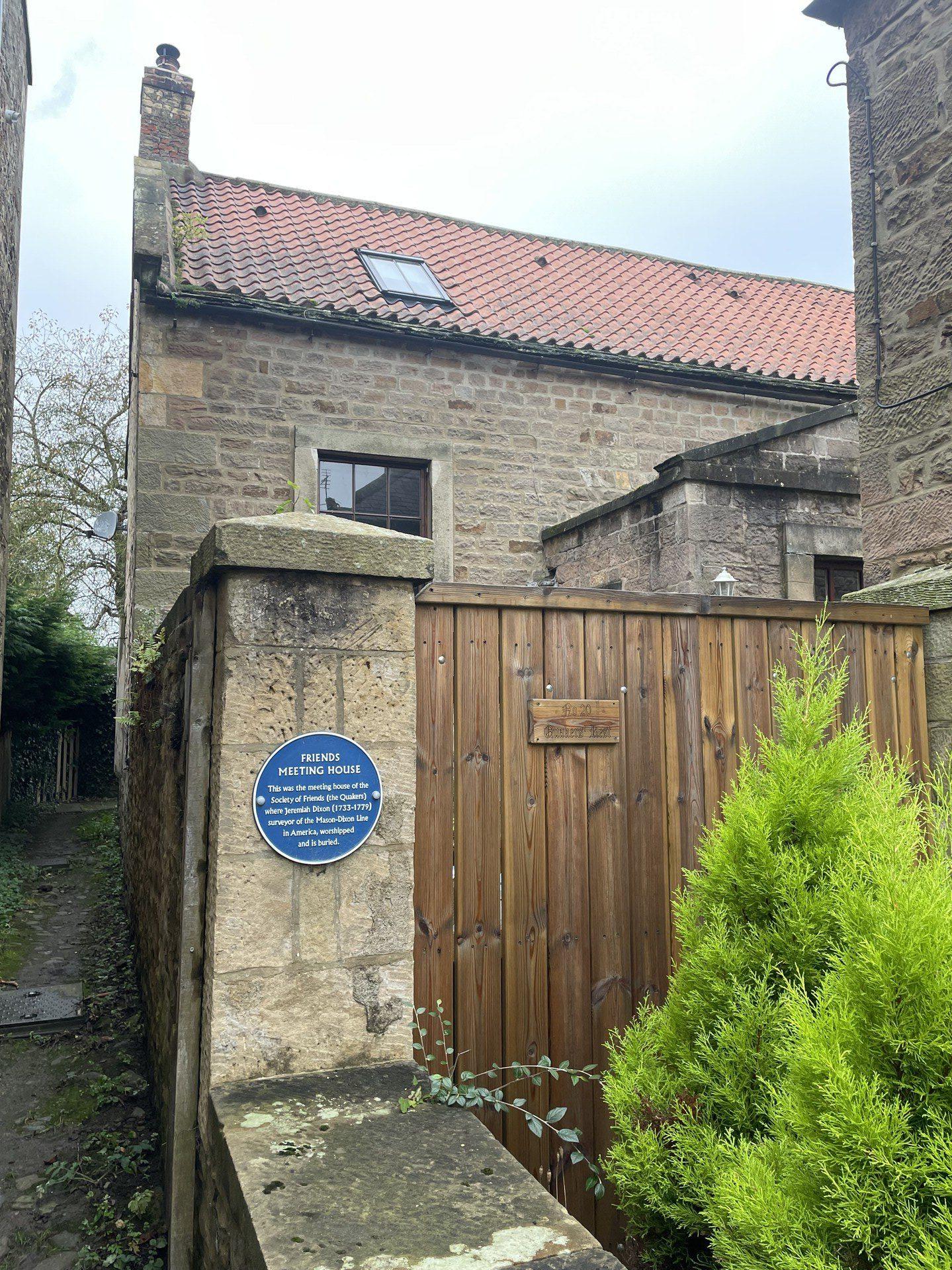 A blue plaque on a stone column outside of the Friends Meeting House in Staindrop, County Durham