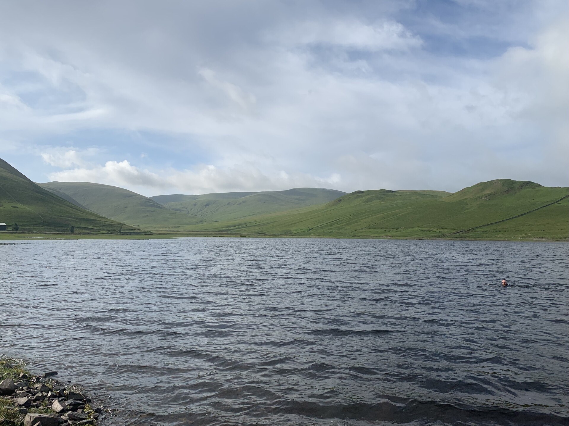 The cold, shallow waves of Fruid Reservoir, with the green slopes of the hills in the background