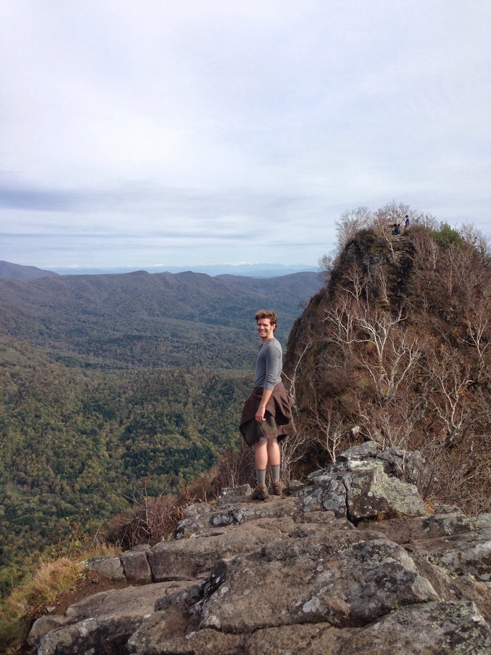 Me, looking over my shoulder from a little distance away, on the summit of Kogane-yama, with the slopes dropping precipitously on either side of me