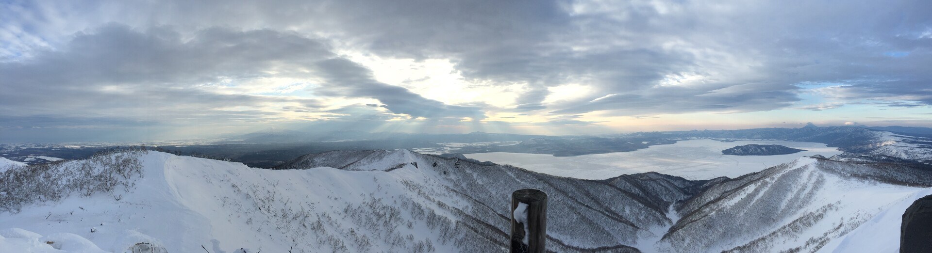 A panorama of snow and forest from the summit of Mokoto-yama