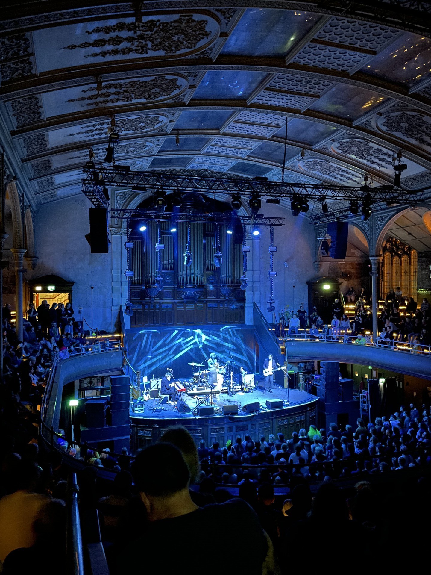 The Mountain Goats on stage at the Albert Hall in Manchester: a soaring Victorian auditorium with people packed in on multiple levels.