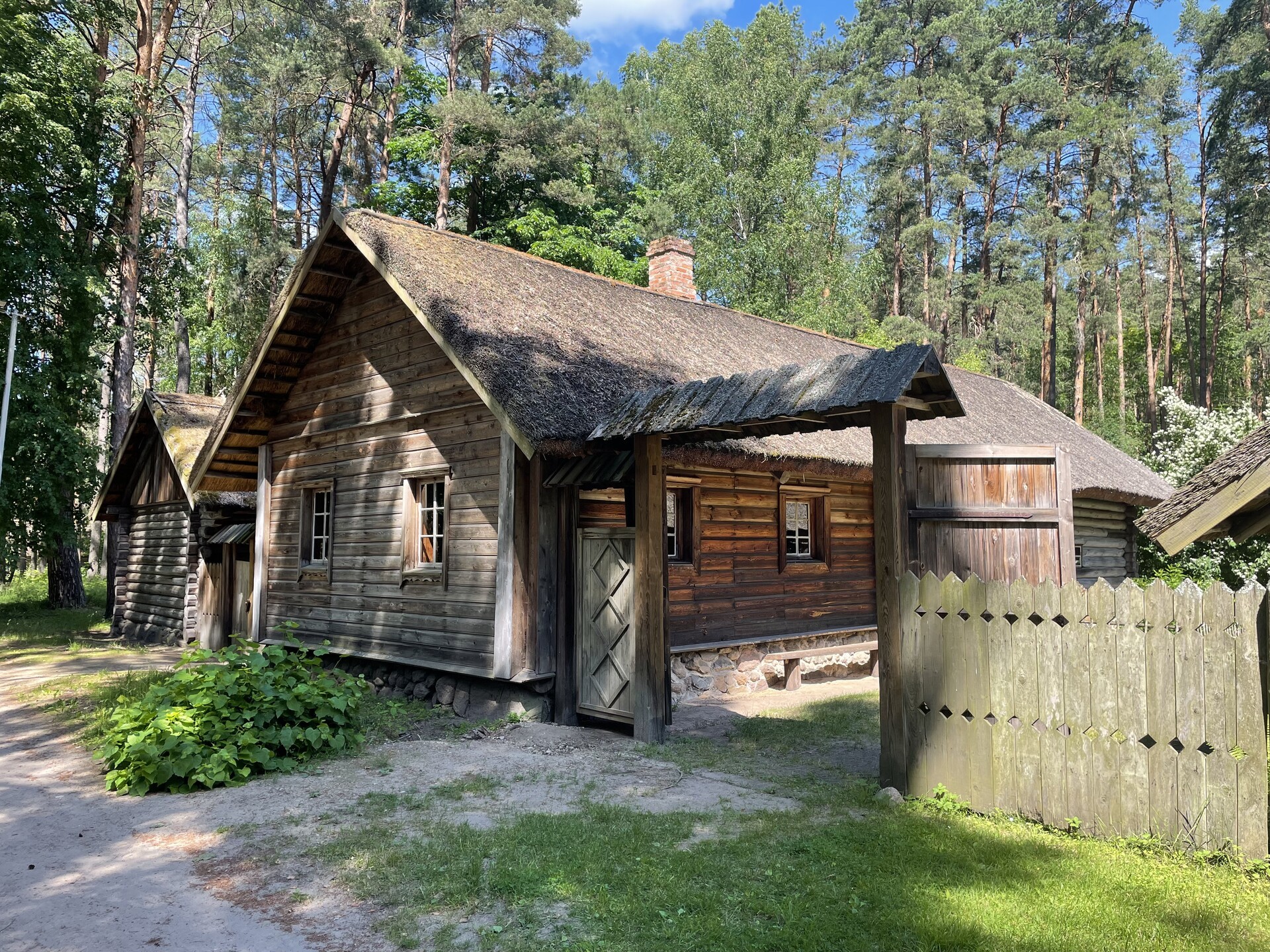 A wooden building with a thatched roof, at the Ethnographic Open-air Museum in Jugla, Latvia