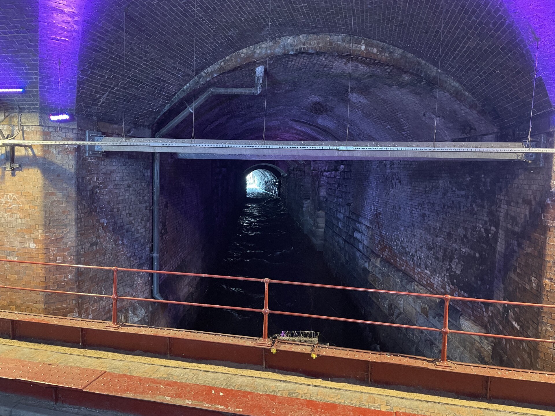 The river Aire running down a brick tunnel under the Leeds railway station