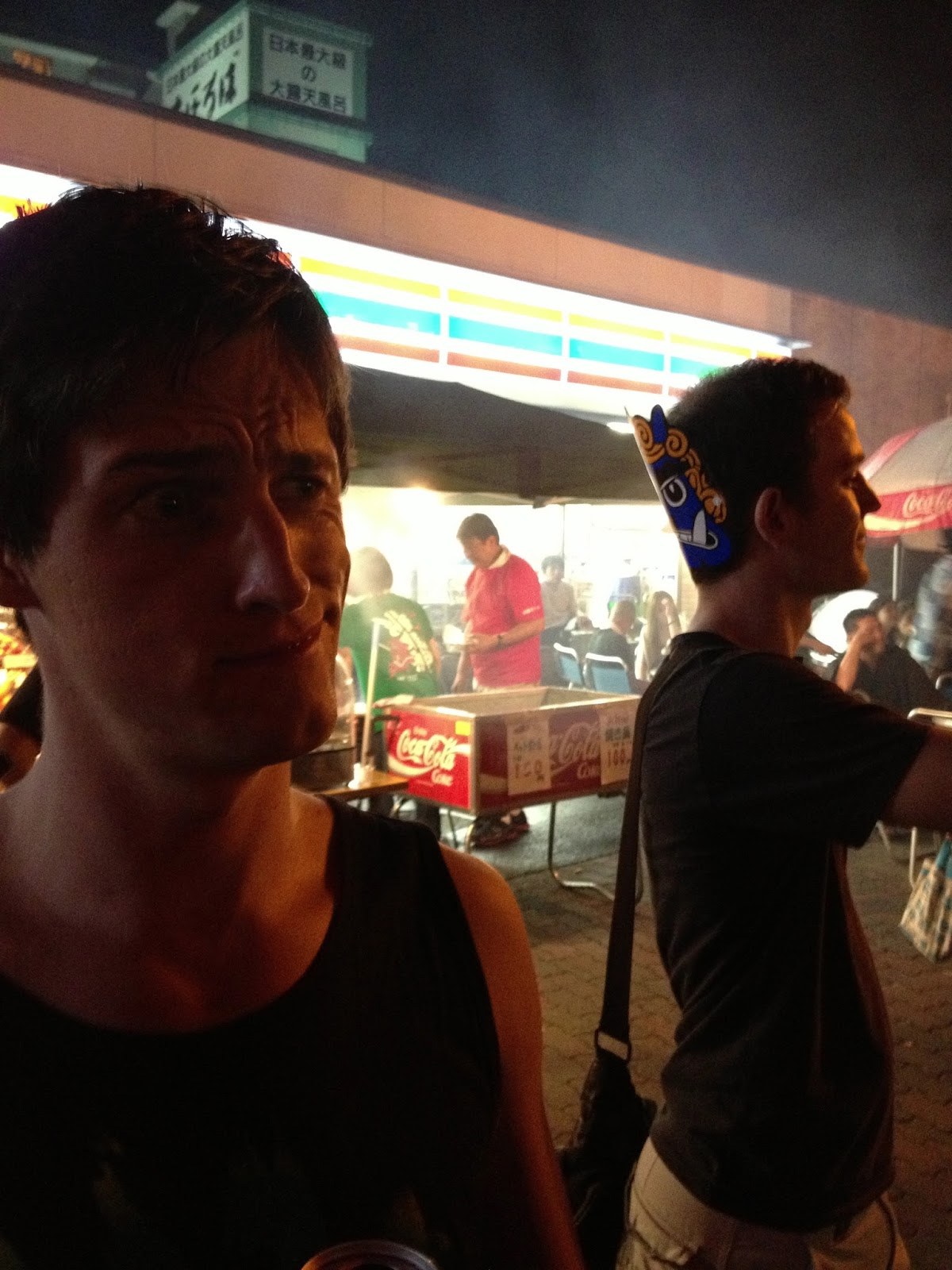 My friend Rory, making a quizzical face at something just outside the frame, standing in front of a brightly-lit 7-11