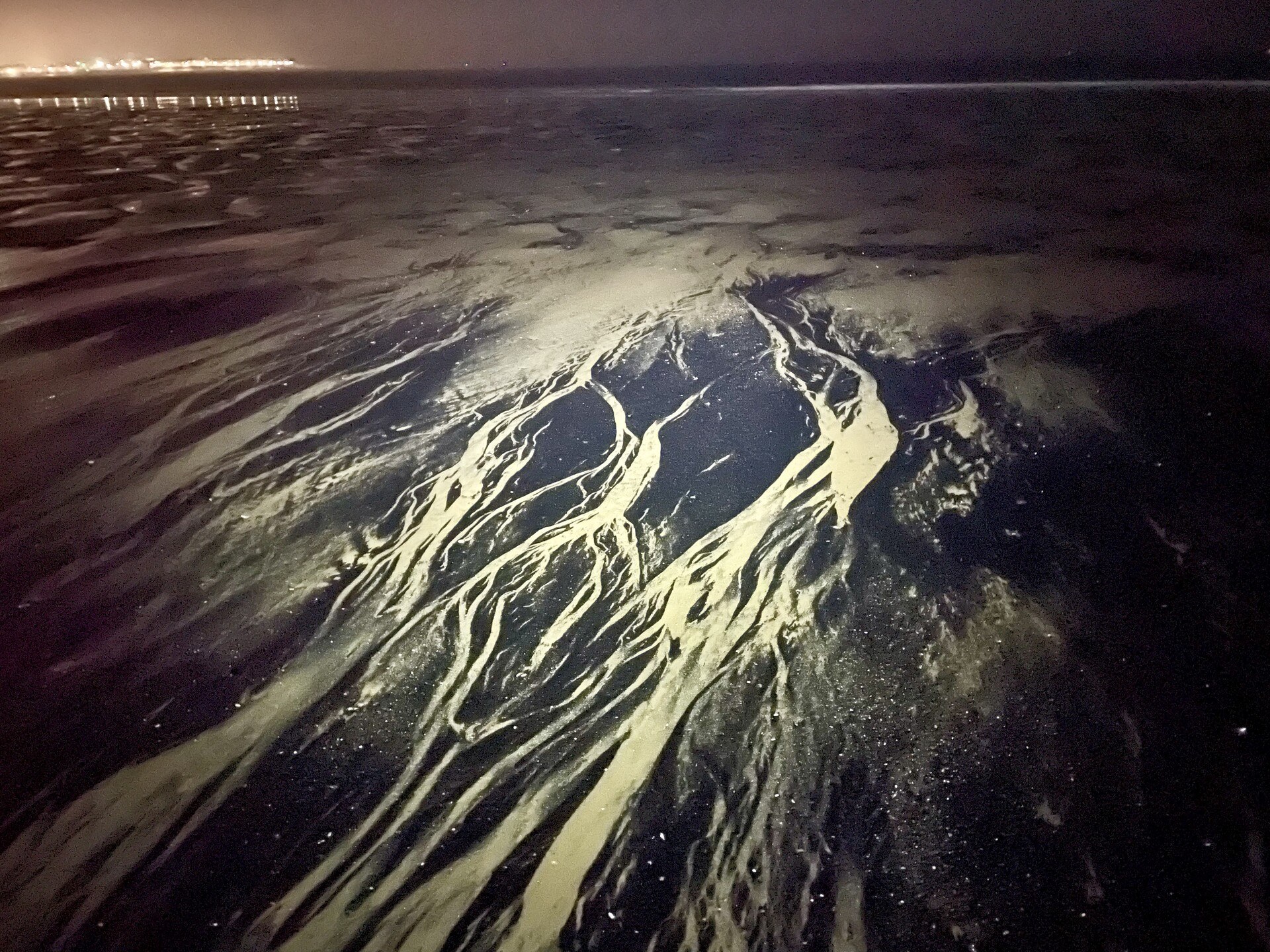 Patterns in the sea coal on the beach in Seaton Carew, with the Headland in the background