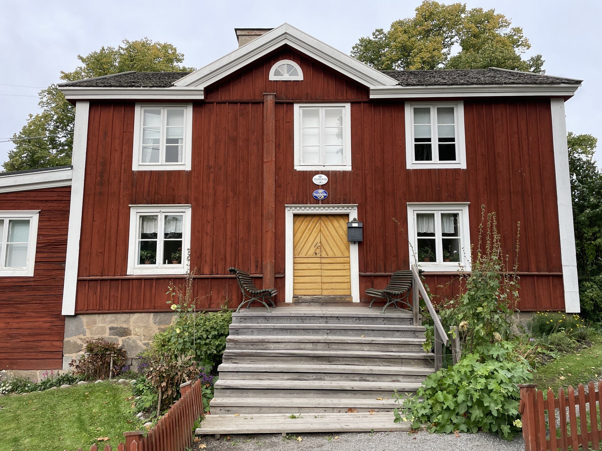 The front plan of an asymmetric red wooden house in traditional Swedish style