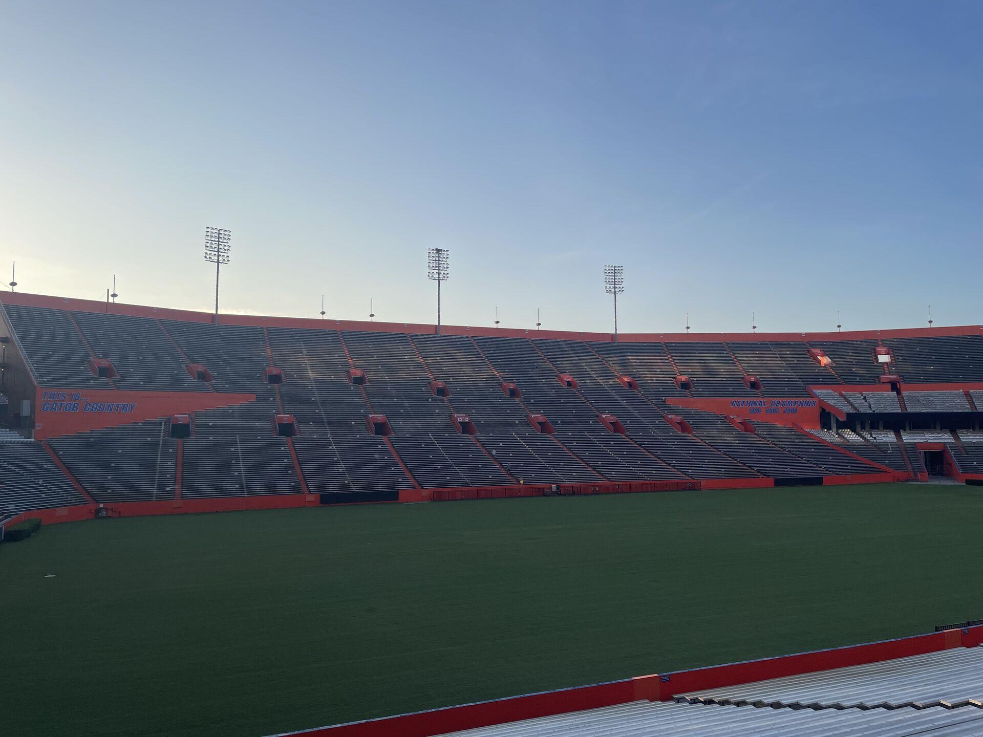 Sunrise over the blue-and-orange grandstands at the Ben Hill Griffin Stadium in Gainesville, FL