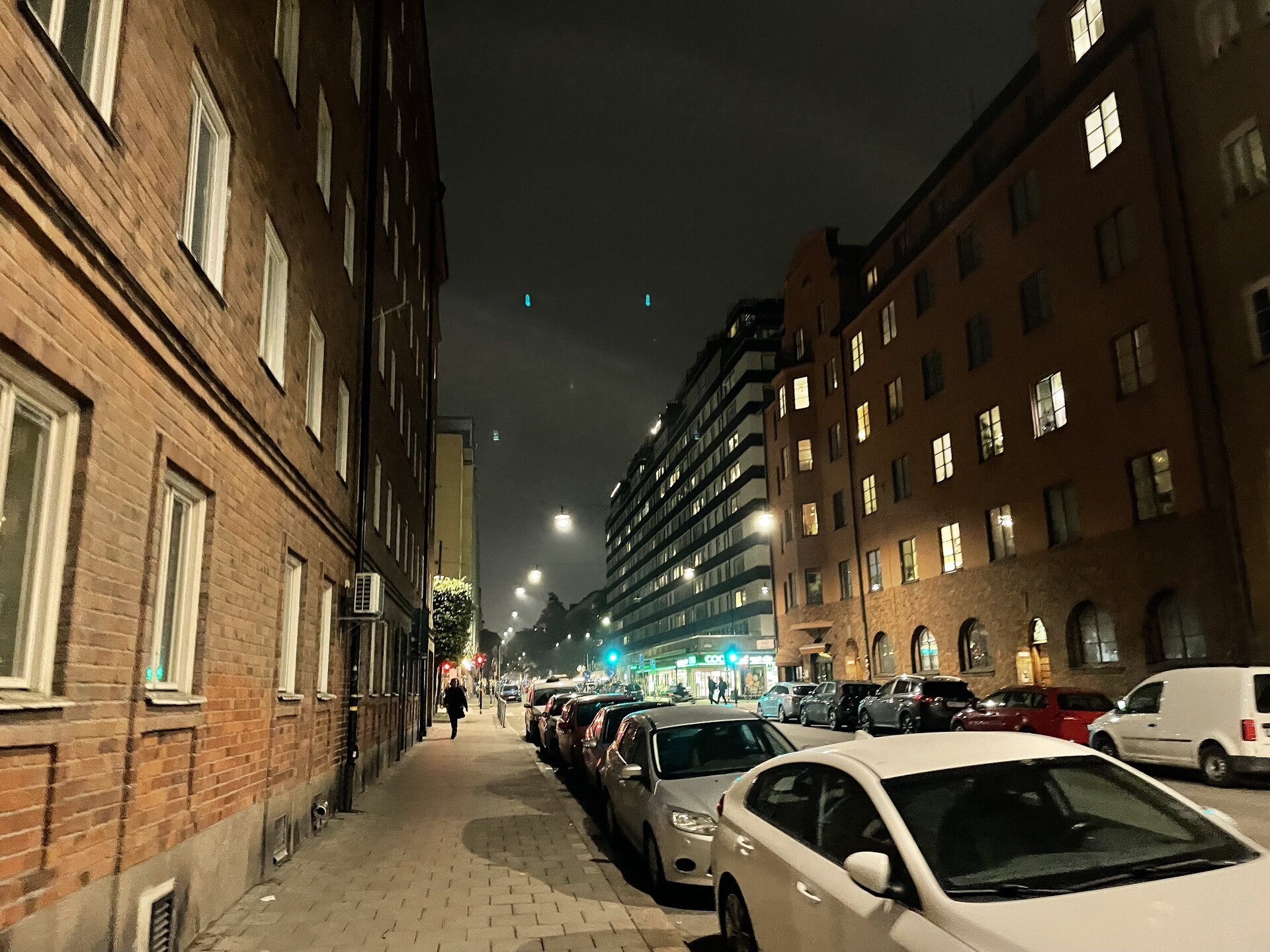 A street in Stockholm at night, with tall apartment buildings either side.