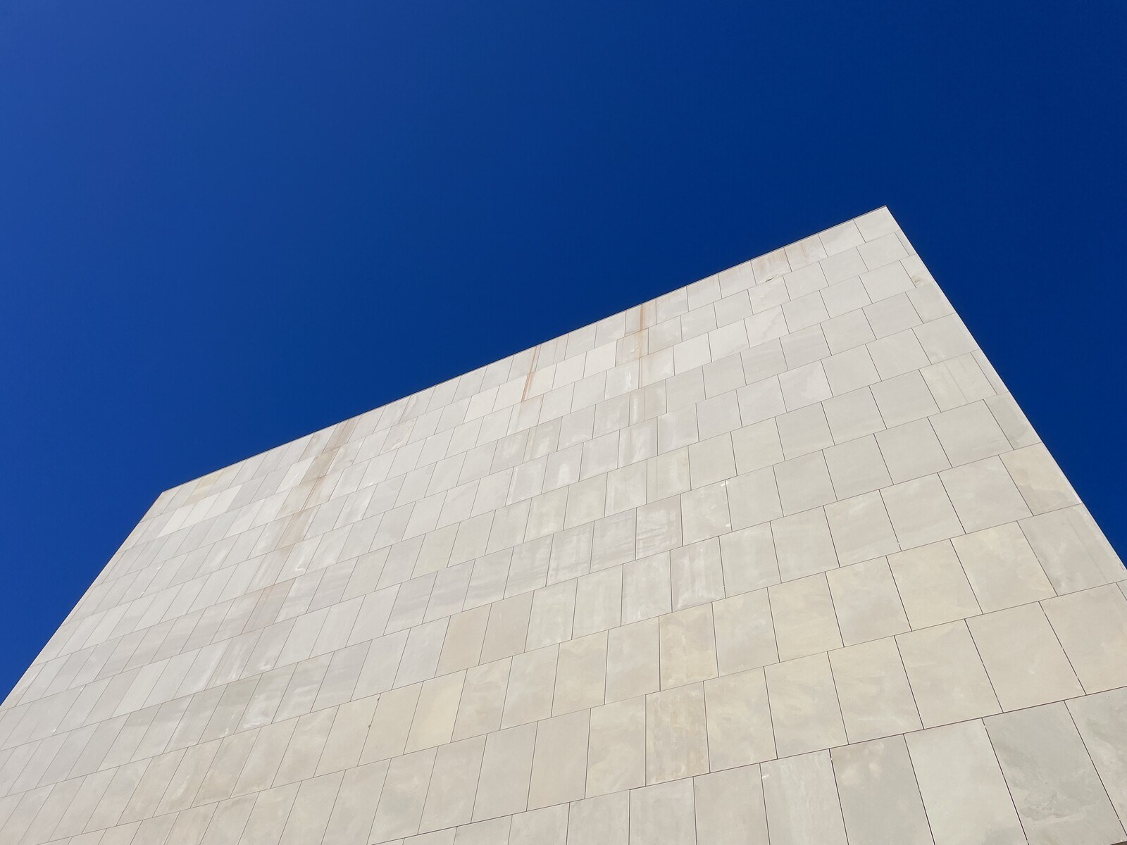 The tall, flat, featureless facade of the Torrevieja theatre, looming into a bright blue sky
