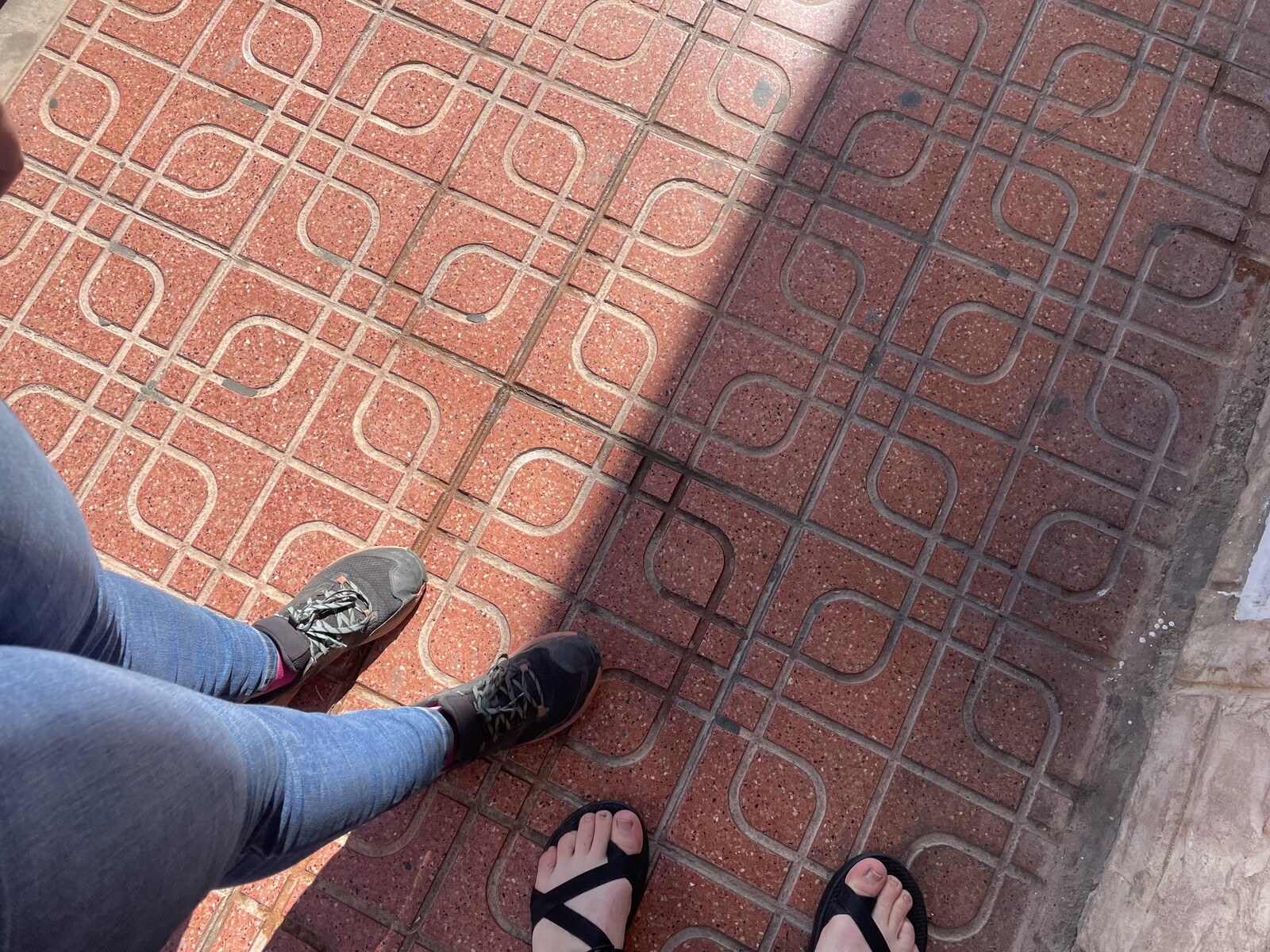 Sam's and my feet on a set of elaborately decorated granite tiles on the sidewalk