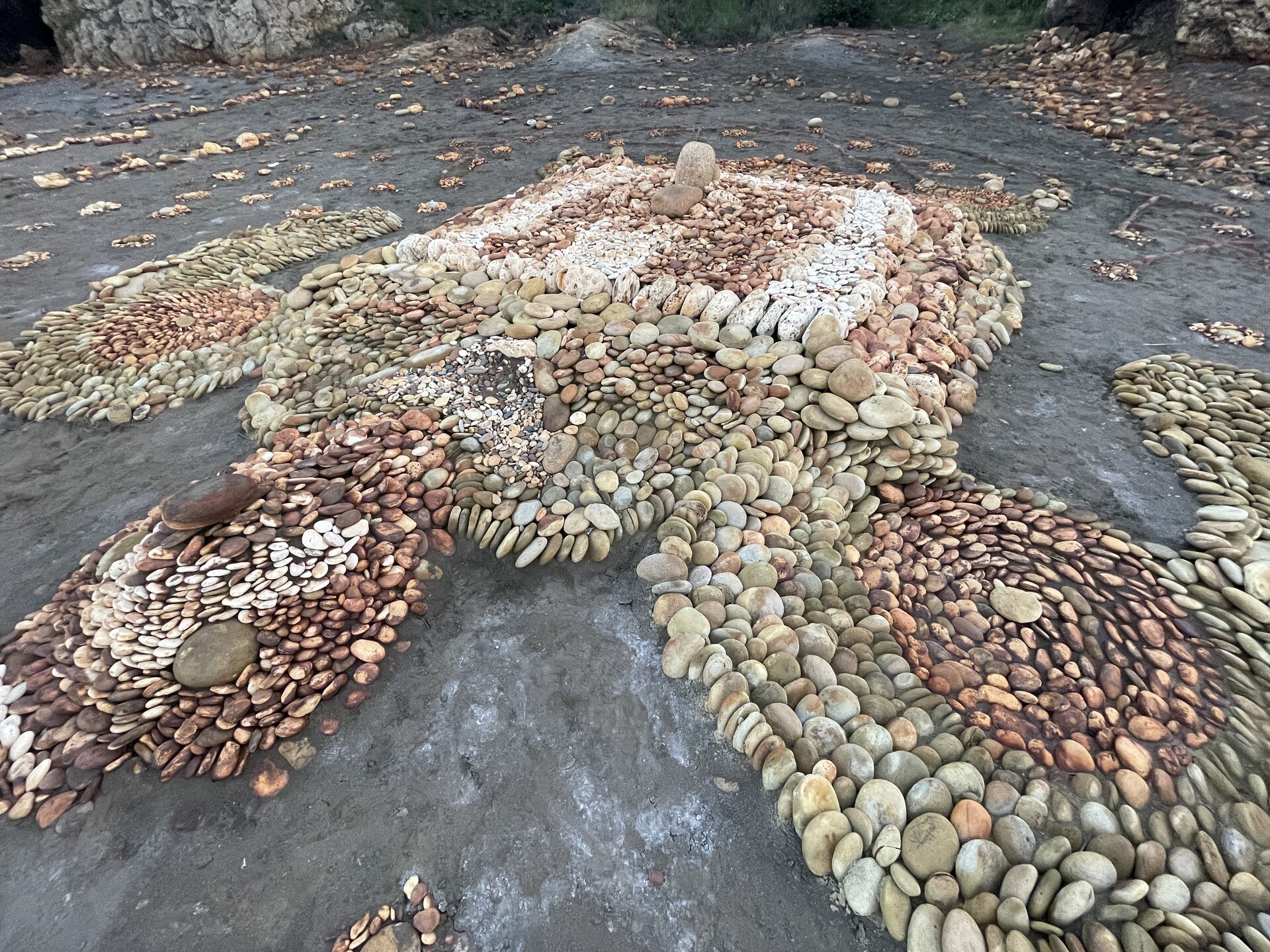 A closeup of thousands of stones in swirling patterns making up a giant sea turtle