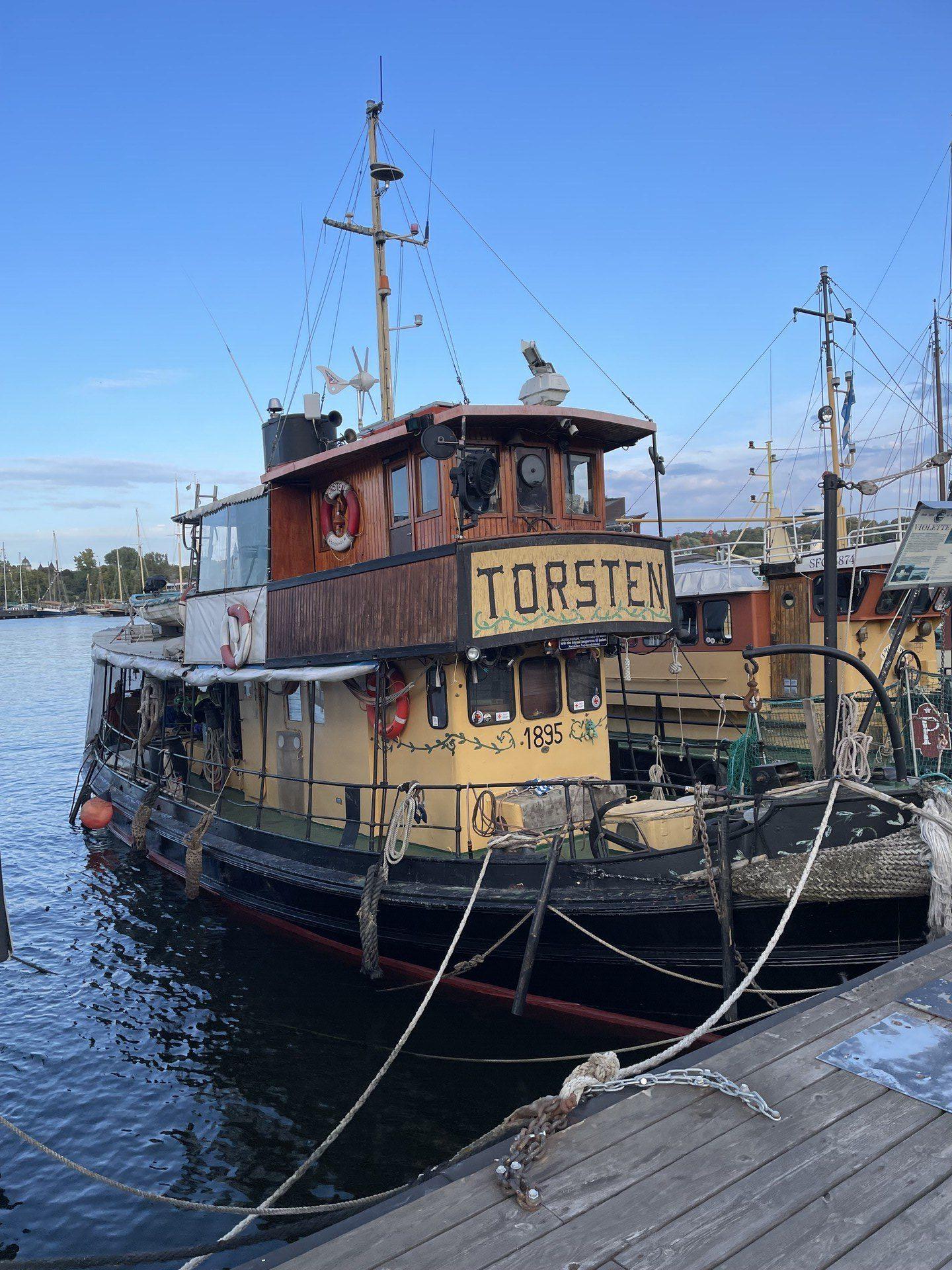 An old boat tied up at dock, with the word