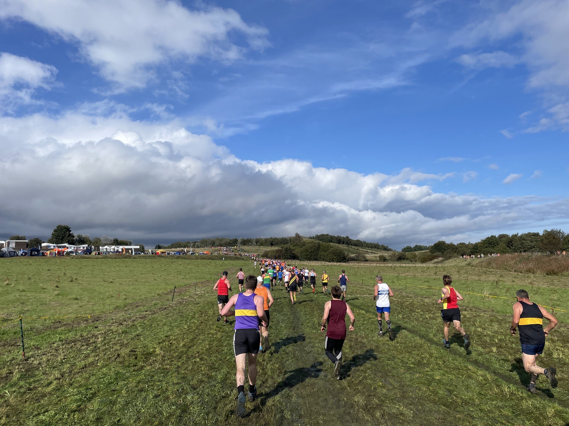 Runners ahead of me, crossing a big grassy field, getting increasingly muddy