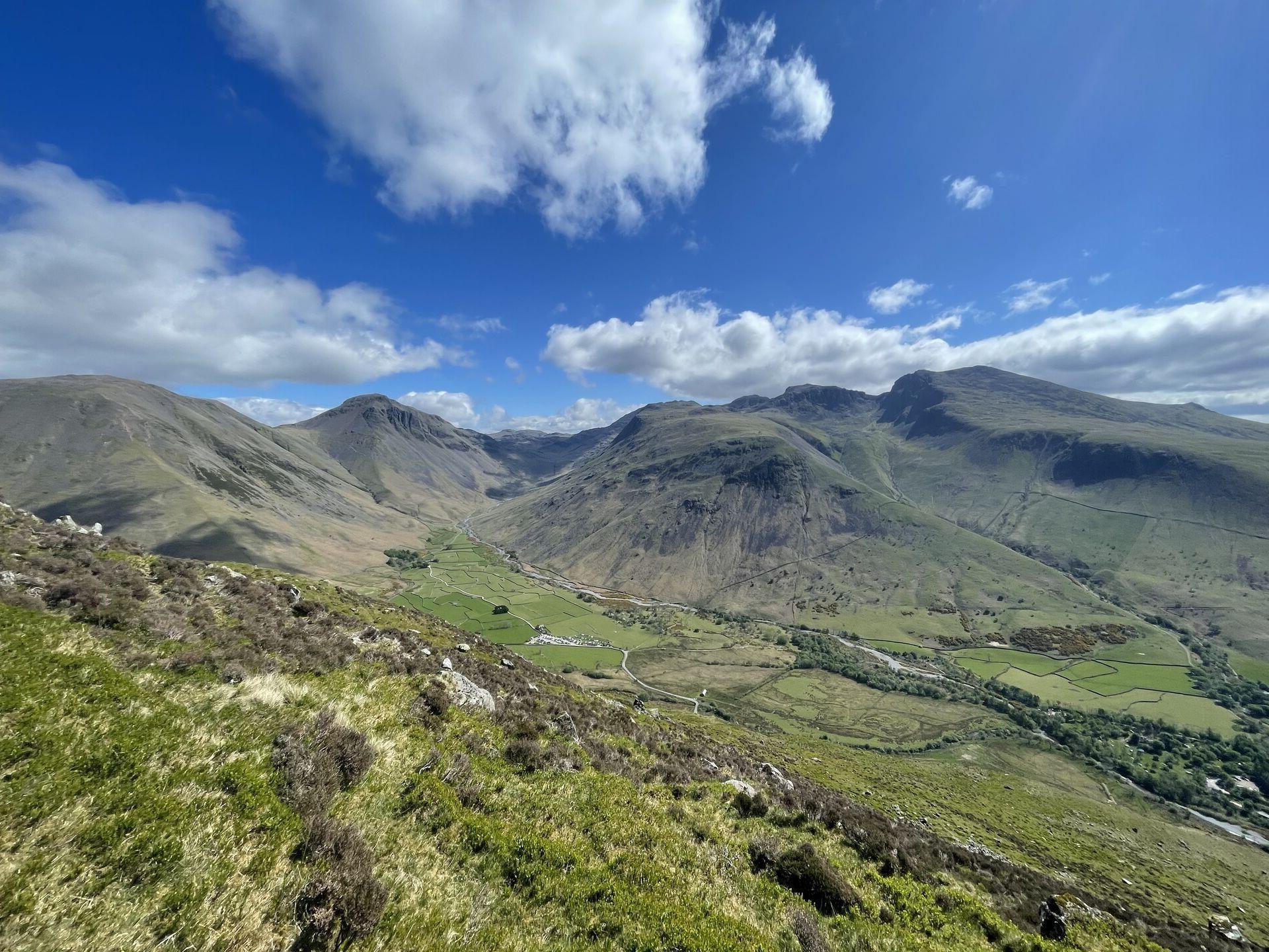 A Lake District vista: rolling green hills dotted with crags, little villages and treelined burns in the bottoms of the valleys