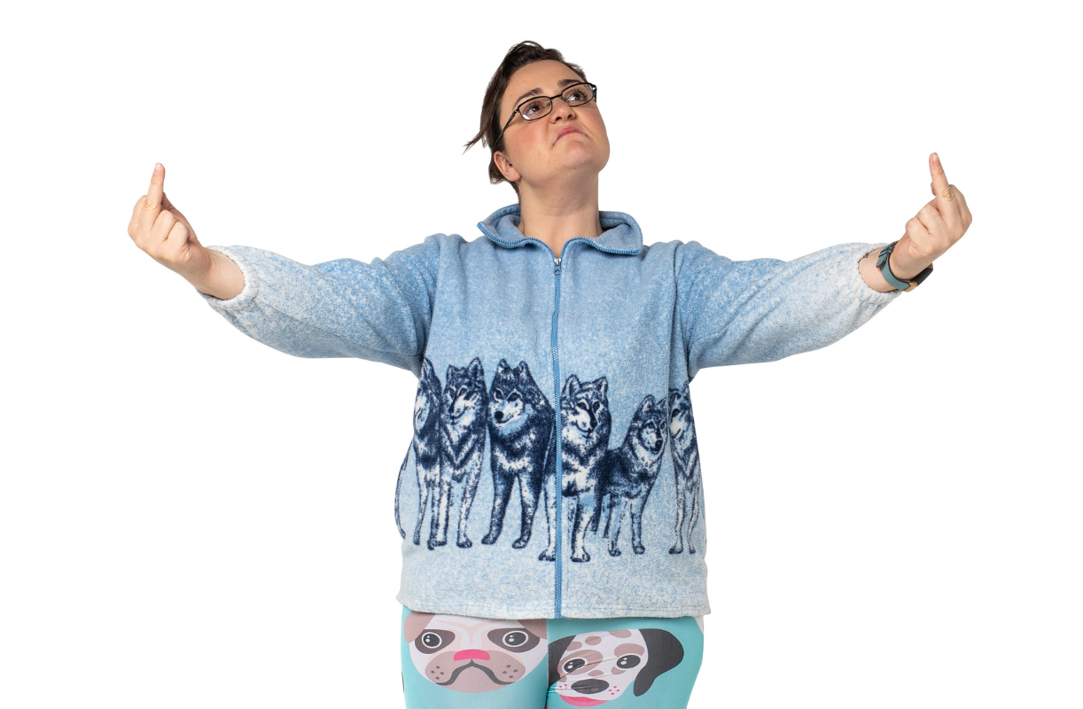 Zoe flipping the bird with both hands, wearing a wolf-print fleece and dog-print tights.